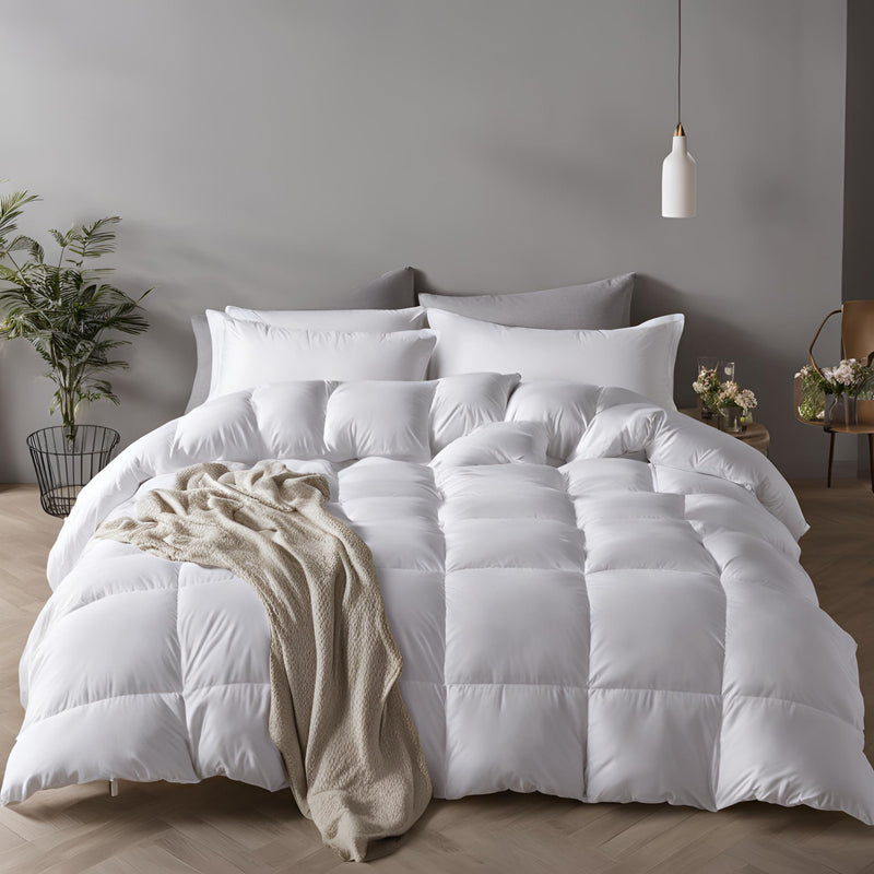 A white duck feather & down duvet displayed on a bed, with a cozy and inviting appearance, in a room with minimalistic decor.
