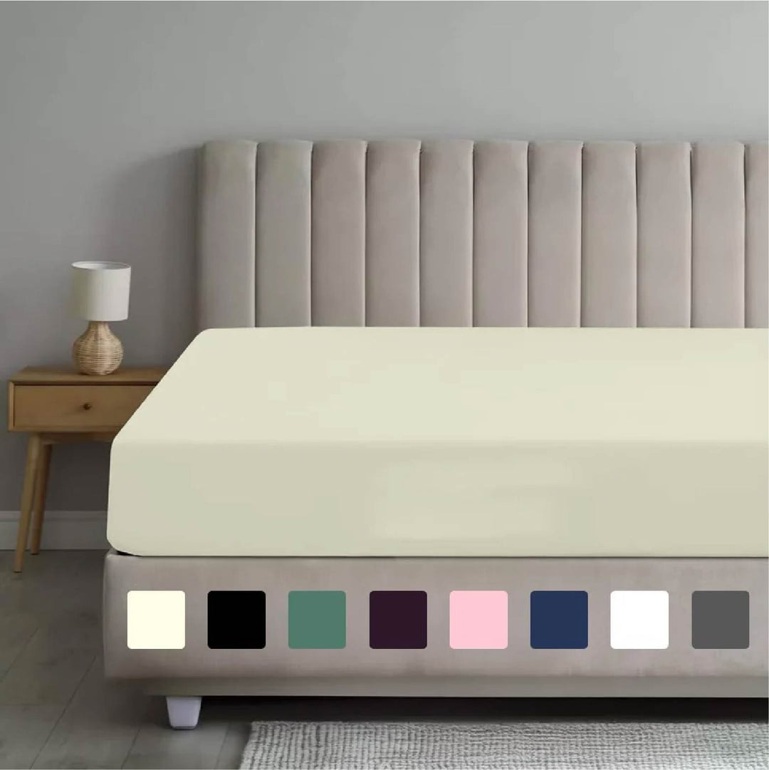 Cream fitted sheet on a bed with a tufted headboard, showcasing a color palette of available sheet options including black, green, and pink below.