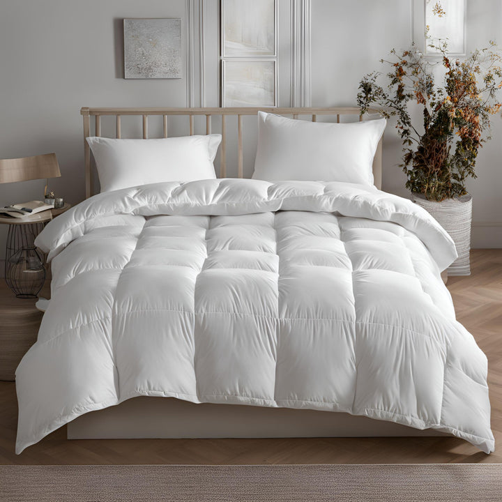 A white goose feather and down duvet on a bed, with matching pillows and a wooden headboard in the background. There is a window with curtains and a decorative plant beside the bed.