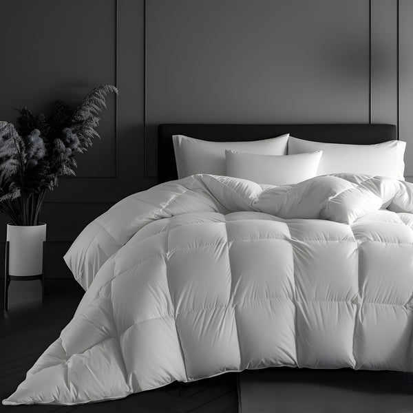 A white, plush goose down duvet presented on a bed, with a subtle pattern that provides a silky-soft texture. The background includes a dark headboard and a plant, enhancing the luxury feel of the product.